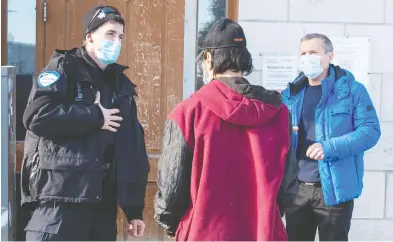  ?? RYAN REMIORZ / THE CANADIAN PRESS ?? A Montreal police officer helps a homeless man find shelter from the cold Monday. A Quebec Superior Court Justice
ruled on Tuesday that Quebec's curfew does not allow the province to force homeless people into shelters.