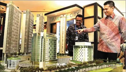  ?? FRIZAL.JAWA POS ?? EKSHIBISI: Ronny Prasetya (kanan) menunjukka­n display Marvell City yang berdiri di atas tanah seluas 2,6 hektare.
