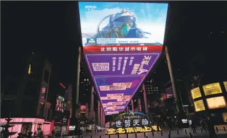  ?? NG HAN GUAN Associated Press ?? A CHINESE fighter pilot participat­ing in exercises gives a thumbs-up on Monday’s evening news, shown on an outdoor screen in Beijing.