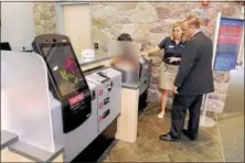  ?? Gene Walsh / Times Herald Staff ?? Marketing manager Fallon Maloney shows Steve Miller how to use Citadel’s Express Banking Machine inside the new Citadel Bank in West Norriton.