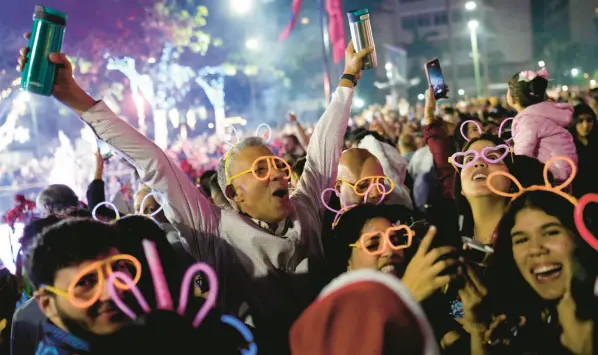  ?? ?? People celebrate the new year at Plaza Altamira in Caracas, Venezuela, early Monday. MATIAS DELACROIX/AP