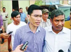  ?? PHA LINA ?? Former RFA reporters Yeang Sothearin (front, in blue shirt) and Oun Chhin (back, in white shirt) are escorted by officials after being detained for questionin­g in Phnom Penh in November.