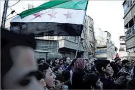  ?? SAMEER AL-DOUMY/GETTY-AFP ?? Syrian men gather in the rebel-held town of Saqba, on the eastern outskirts of the capital Damascus, during a demonstrat­ion Friday against the Syrian government.