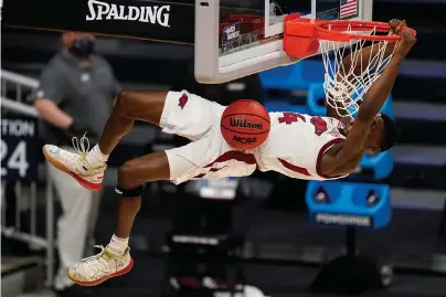  ?? The Associated Press ?? Q Arkansas guard Davonte Davis (4) gets a dunk against Texas Tech in the second half Sunday’s second-round game in the NCAA men’s basketball tournament at Hinkle Fieldhouse in Indianapol­is.