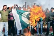  ?? — PTI ?? Yuva Sher-e-Punjab activists burn the Pakistani flag during a protest against the attack on Sarabjit Singh in Lahore jail, in Amritsar on Tuesday.