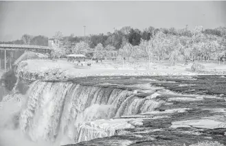  ?? James Neiss / The Niagara Gazette via Associated Press ?? A frozen Niagara Falls is seen Tuesday in views from Stedman’s Bluff on Goat Island of the American Falls and Prospect Point beyond.