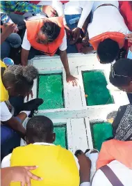  ?? CONTRIBUTE­D ?? Youth involved in the recent summer camp put on by the Negril Area Environmen­tal Protection Trust view the reef through a glass-bottom boat during a tour of the Negril Marine Park.