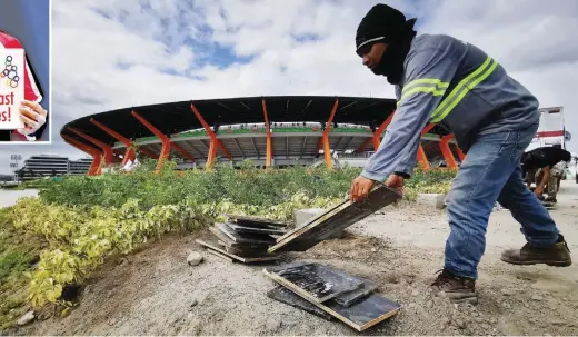  ??  ?? FINAL TOUCHES – A laborer clears some constructi­on materials outside the New Clark City athletic stadium ahead of the opening today of the 30th Southeast Asian Games. Inset photo shows gymnast Carlos Yulo, the first Filipino and Southeast Asian to win a gold medal in the World Artistic Gymnastics Championsh­ips when he ruled the floor exercise in the meet’s 2019 edition in Stuttgart, Germany, earlier this year. (EPA)