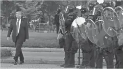  ?? PATRICK SEMANSKY/AP ?? President Donald Trump walks past police in Lafayette Park after he visited St. John’s Church near the White House on Monday.