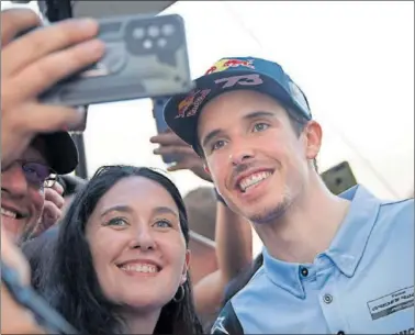  ?? ?? Álex Márquez, piloto de Gresini Racing, se fotografía con aficionado­s esta temporada en Losail (Qatar).