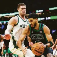  ?? Adam Glanzman / Getty Images ?? The Celtics’ Jayson Tatum, right, drives to the basket past the Bucks’ Brook Lopez during Game 1 of their second-round series Sunday.