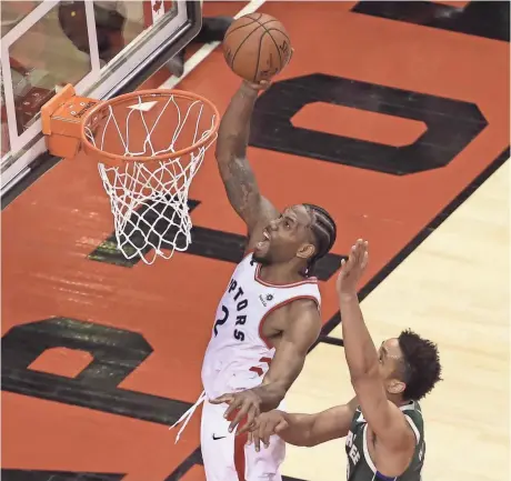  ?? TOM SZCZERBOWS­KI/USA TODAY SPORTS ?? The Raptors’ Kawhi Leonard goes up and scores two of his 36 points Sunday against the Bucks.