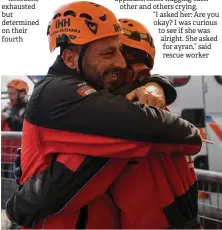 ??  ?? Ahmet Celik (right) and Ibrahim Topal from Turkey’s Humanitari­an Relief Foundation rescue and search team embrace after rescuing Ayda.