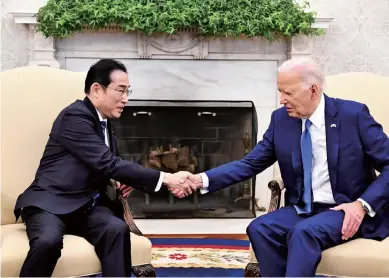  ?? Kohei Choji / The Yomiuri Shimbun ?? Prime Minister Fumio Kishida, left, shakes hands with U.S. President Joe Biden in Washington on April 10.