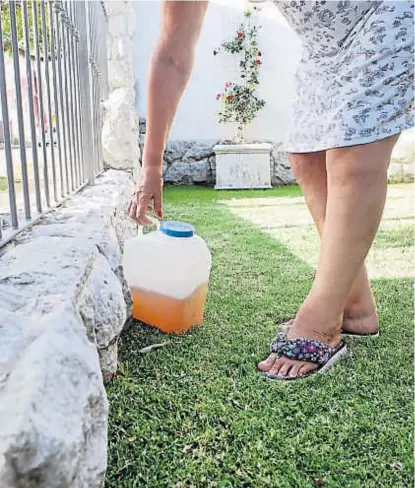  ?? (GENTILEZA PUNTAL) ?? En Río Cuarto. Una mujer deja contra la reja de su casa el bidón con la orina para Biomás.