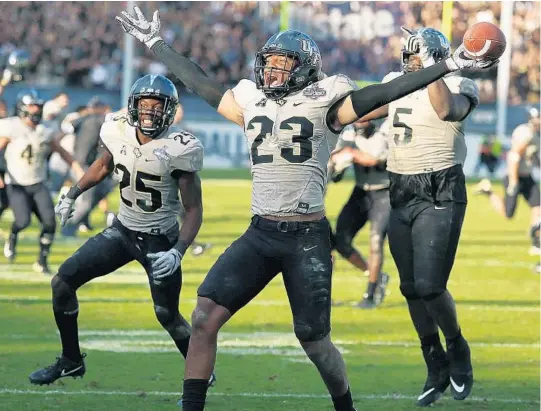  ?? PHOTOS BY STEPHEN M. DOWELL/STAFF PHOTOGRAPH­ER ?? UCF defensive back Tre Neal (23) celebrates his intercepti­on that sealed the victory for the Knights in their 2OT triumph over Memphis on Saturday afternoon at Spectrum Stadium.