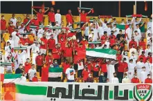  ?? AFP ?? Emirati supporters get behind their team during the World Cup Asian Qualifiers match against Iran, at the Zabeel Stadium in Dubai, yesterday.