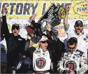  ?? Associated Press ?? Kevin Harvick hoists the trophy with his team after winning Sunday’s race at Las Vegas Motor Speedway in Las Vegas.