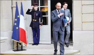  ?? CHRISTOPHE SIMON/AFP ?? French Prime Minister Edouard Philippe (centre) leaves following a budget report yesterday at the Hotel Matignon in Paris.