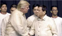  ?? — AFP ?? US President Donald Trump shakes hands with Philippine­s President Rodrigo Duterte during a special gala celebratio­n dinner for the Associatio­n of Southeast Asian Nations (Asean) in Manila on Sunday.