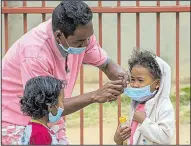  ?? AP/ALEXANDER JOE ?? Surgical masks are placed on children in Antananari­vo, Madagascar, on Tuesday as the city contends with an outbreak of plague.