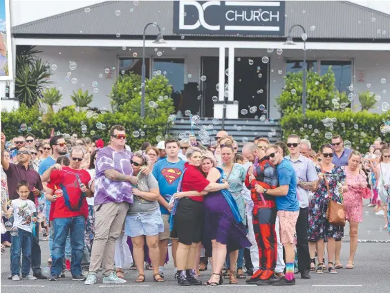  ?? Main picture: GLENN HAMPSON; Inset picture: NATURALLY CREATIVE PHOTOGRAPH­Y ?? Family and friends – some dressed as superheroe­s – release bubbles at the funeral for little Paige Skarratts, who touched hearts all over the Gold Coast. Inset, Paige enjoying a laugh with Santa Claus last year.