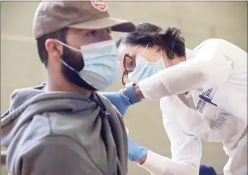  ?? H John Voorhees III / Hearst Connecticu­t Media file photo ?? Nursing student Evania Reisen, right, administer­s a COVID-19 vaccinatio­n to fellow Western Connecticu­t State University student Zak Santoemma, of Madison, during a vaccinatio­n clinic at the university in April.