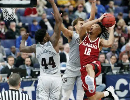  ?? JEFF ROBERSON — THE ASSOCIATED PRESS ?? Alabama’s Dazon Ingram (12) heads to the basket past Texas A&M’s Robert Williams (44) and D.J. Hogg during the second half in an NCAA college basketball game at the Southeaste­rn Conference tournament Thursday, in St. Louis. Alabama won 71-70.