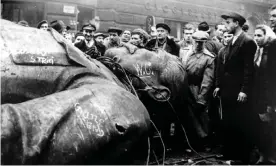  ?? Photograph: Arpad Hazafi/AP ?? People gather around a fallen statue of Soviet leader Josef Stalin in front of the National Theatre in Budapest, Hungary, 1956.