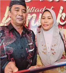  ??  ?? Zabidah dan suami, Azmi Osman mengambil skrol bagi pihak anaknya yang meninggal dunia.