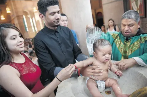  ?? MATT MCCLAIN/ WASHINGTON POST ?? The Sacred Heart Catholic Church community celebrates a baptism in Washington, D.C., last month.