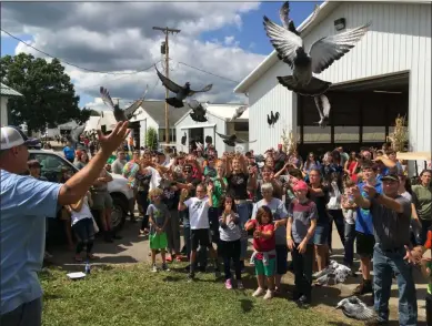  ?? RICHARD PAYERCHIN — THE MORNING JOURNAL ?? Homing pigeons take flight as Todd Clement, left, leads the release at the Lorain County Fair on Aug. 24.