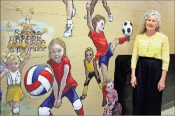  ?? Jeremy stewart ?? Local artist Susan Waters recently finished a 10x24 mural depicting scenes of children playing sports for the entrancewa­y of the Rockmart recreation gym, 815 College St.