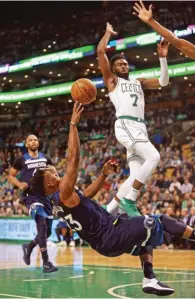  ??  ?? STUART CAHILL/BOSTON HERALD The Timberwolv­es’ Jimmy Butler (L) tries to flip a shot from the floor while being guarded by the Celtics’ Jaylen Brown during an NBA clash in Boston on January 5, 2018.