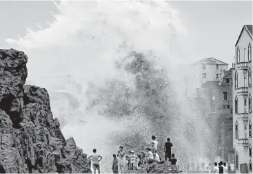  ?? AFP / Getty Images ?? Residents gather Saturday to see huge waves stirred up by Typhoon Soudelor as the storm drew near mainland China in Wenling, in east China’s Zhejiang province. Soudelor left a trail of debris in Taiwan and Saipan.