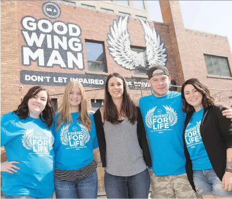  ?? TROY FLEECE ?? Victoria’s Tavern is supporting SGI’s Be A Good Wingman campaign to fight drunk driving by having the logo and slogan painted on the side of its building. Helping push the message inside are employees Campbell Mack, Danielle Lewis, Chantelle Kraushaar,...