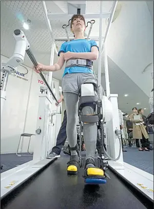  ?? AP/EUGENE HOSHIKO ?? A model demonstrat­es the Welwalk WW-1000, a wearable robotic leg brace designed to help partially paralyzed people walk, at Toyota Motor Corp.’s head office in Tokyo last week.