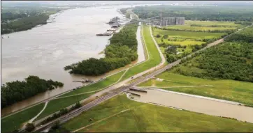  ?? The Associated Press ?? REDUCING EROSION: This May 1 photo shows the Davis Pond Diversion, a project that diverts water from the Mississipp­i River, left, into the Barataria Basin to reduce coastal erosion in St. Charles Parish, La. Engineers hope to remake some eroded marshes by siphoning off sediment-rich water that can be channeled into coastal basins.