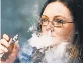  ?? RON JOHNSON, AP ?? Stephanie Wilson of Breathe Vapor exhales e- cigarette smoke.