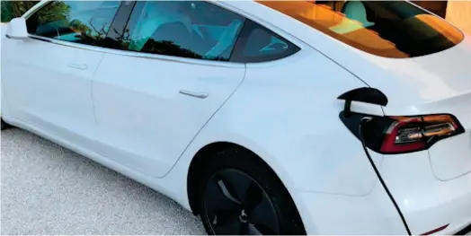  ?? ?? Un véhicule Tesla Model 3 est en train de recharger sa batterie sur une prise de charge à domicile. (Crédits : dr)