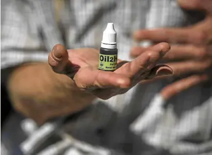  ?? —AFP ?? CANNABIS OIL South African Gerd Bader shows a flacon containing cannabis oil produced from his plant in Johannesbu­rg, South Africa.