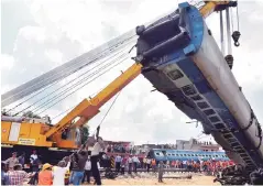  ?? PHOTO: PTI ?? A mangled coach of Utkal Express train being hauled of the tracks by a crane at the accident site in Khatauli near Muzaffarna­gar on Sunday. A preliminar­y probe has found that maintenanc­e work was being carried out on the tracks which might have caused...