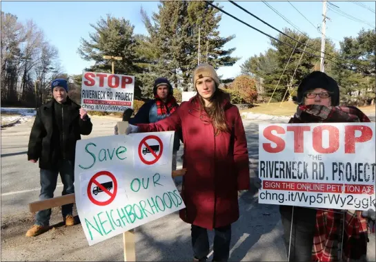  ?? JULIA MALAKIE — LOWELL SUN ?? Residents around Riverneck Road in Chelmsford are objecting to the siting of a distributi­on facility on Riverneck Road, and the conversion of a fire access drive across the street into a truck route. From left, Sean Campbell, Town Meeting Rep. Brian Latina, Town Meeting Rep. Katie Melville and Sandy Gianacopli­s at the site on Feb. 3. The property where the distributi­on facility would be developed is at rear.