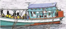  ?? AP ?? A fishing boat carries Vietnamese asylum seekers April 14 near the shore of Australia’s Christmas Island.