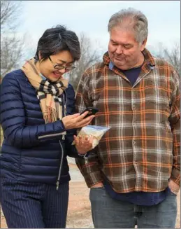  ?? PHOTOS BY MAY ZHOU / CHINA DAILY ?? Zhang Qiang, president of China Jiushan Trading Co, talks to farmer Johnny Rose about soybeans produced at the Rose Farm.