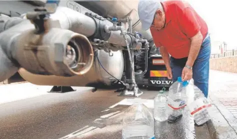  ?? // ÁLVARO CARMONA ?? Un hombre llena varias garrafas de agua potable en un municipio del Norte de Córdoba