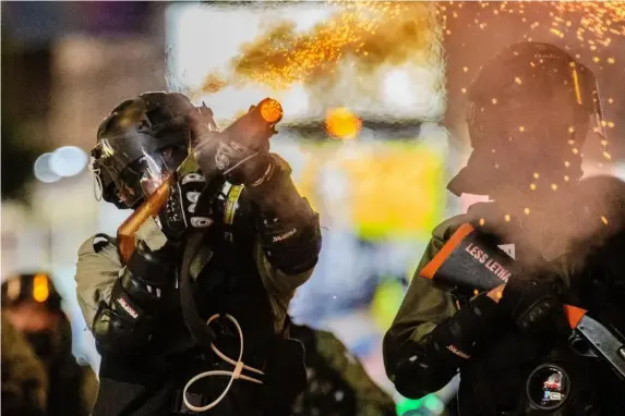  ?? (AFP) ?? Armed police fire at pro-democracy protesters in Hong Kong