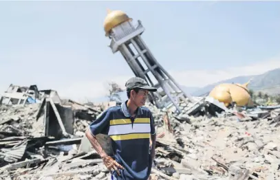  ?? Picture: EPA-EFE ?? ALONE. Mohammad Rizal, 57, stands in the rubble at an earthquake devastated area in Palu, Indonesia, yesterday. Rizal lost his wife, two sons and a nephew.