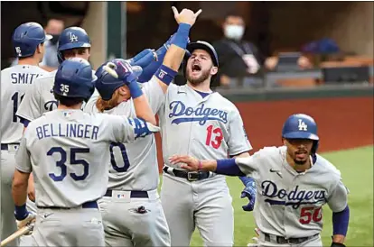  ?? CURTIS COMPTON / ATLANTA JOURNAL-CONSTITUTI­ON VIA AP ?? The Dodgers’ Max Muncy (13) celebrates his grand slam with teammates during the first inning against the Braves in Wednesday’s Game 3 of the National League Championsh­ip Series in Arlington, Texas.