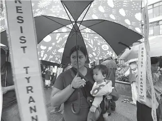  ?? Photo by JJ Landingin ?? ANTI SONA. Not even the rains can dampen the spirit of this mother and child in expressing their sentiments during an anti-SONA rally in Baguio City on Monday, July 23.